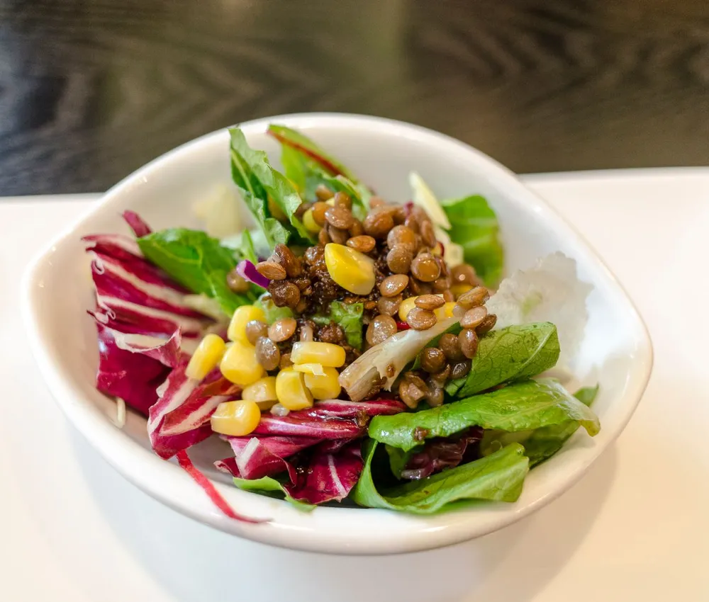 Lentils and sweetcorn served over green and red salad leaves
