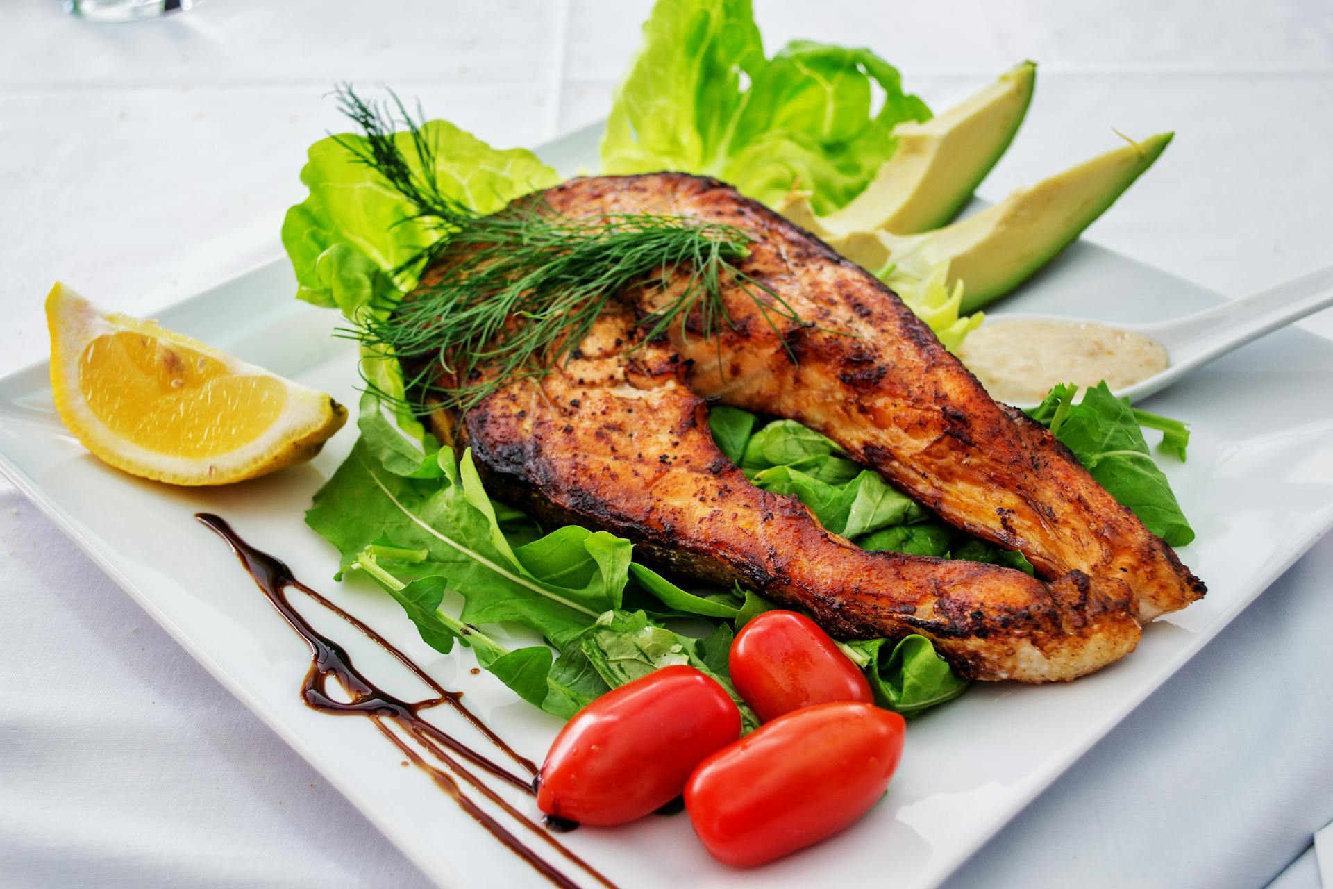 Grilled fish with avocado, lettuce and tomatoes
